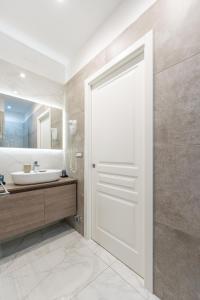 ein Badezimmer mit einer weißen Tür und einem Waschbecken in der Unterkunft Maison Morghen in Neapel