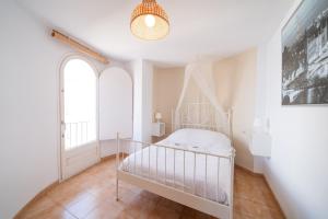 a white crib in a room with a window at WeHostYou - Bel Appartement Empuriabrava, Gran Reserva 17 in Empuriabrava