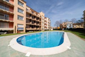 a swimming pool in front of a building at WeHostYou - Bel Appartement Empuriabrava, Gran Reserva 17 in Empuriabrava