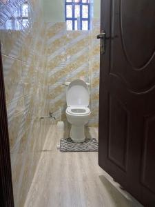 Laucinas homes في ناكورو: حمام به مرحاض وجدار خشبي