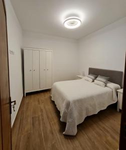 a white bedroom with a bed and wooden floors at Casa Antonico in Garachico