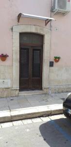 a building with a wooden door on the side of it at CASA GENTILE in Giovinazzo