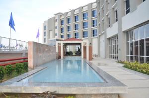 une piscine en face d'un bâtiment dans l'établissement Maha Bodhi Hotel.Resort.Convention Centre, à Bodh Gaya