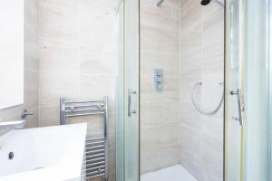 a bathroom with a shower with a toilet and a sink at 4 Bedroom House 2 baths Dagenham in Dagenham