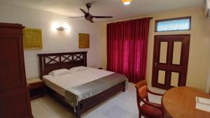 a bedroom with a bed and a ceiling fan at Jayaa Villas Bolgoda - Full Villa in Panadura