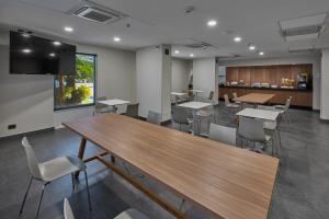 une salle à manger avec des tables, des chaises et une télévision dans l'établissement City Express by Marriott Los Mochis, à Los Mochis