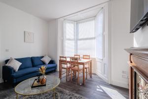 Una sala de estar con un sofá azul y una mesa. en Stockton Lodge, en Hartlepool
