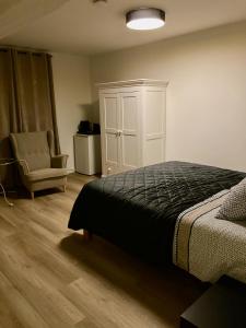 een slaapkamer met een bed, een kast en een stoel bij Hoeve de Hoge Swaen in Maastricht
