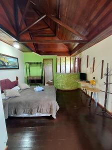 Un dormitorio con una cama y una mesa. en Pousada Inconfidência Mineira, en Ouro Preto