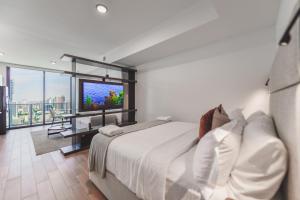 a bedroom with a large bed and a television at Bayside Luxury: Studio Near Bayfront Park in Miami