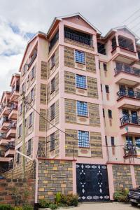 een hoog roze gebouw met veel ramen bij Laucinas homes in Nakuru