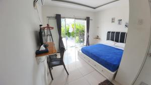 - une chambre avec un lit, une chaise et une fenêtre dans l'établissement Robiu Bed & Breakfast, à Banyuwangi