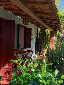 patio con pergolato in legno e TV di Suíte Charmosinha a Caraíva