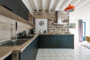 a kitchen with blue cabinets and a brick wall at Refuge de Baden - cadre idyllique 6 pers in Larmor-Baden +20 photos