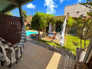 a patio with a hammock and a pool at Pousada Flor De Jambú in São Miguel do Gostoso +17 photos
