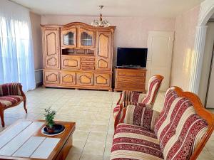 a living room with a couch and a tv at Villa Briconico in Gonesse