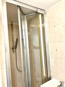 a shower with a glass door in a bathroom at Westfield London Shepherds Bush in London