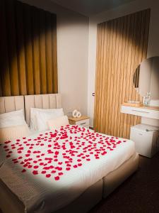 Una cama con un montón de rosas rojas. en Aromë natyre by AlaraFarm, en Durrës