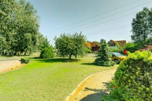 a grassy yard with a driveway and a house at Highway House in Kecskemét