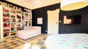 1 dormitorio con silla blanca y estanterías de libros en Matilde Rooms, en La Spezia