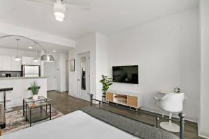 Il comprend un salon avec des murs blancs et une télévision. dans l'établissement Serene Studio Apartment in Hyde Park - Del Prado 706, à Chicago