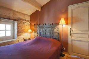 a bedroom with a bed and a window at Le Capitaine in Bonnieux