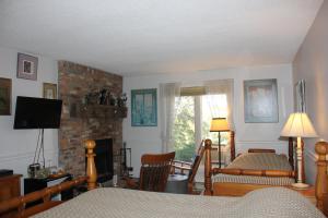 a living room with a bed and a fireplace at Pretty River Valley Country Inn in Nottawa