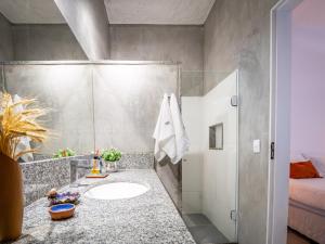 a bathroom with a sink and a shower at Green Loft - ITAIPAVA in Petrópolis +26 photos