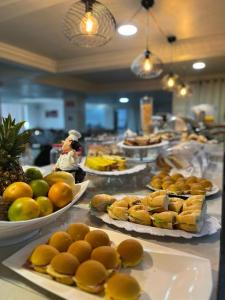 a buffet with many plates of food on a table at Hotel Fenice in Foz do Iguaçu