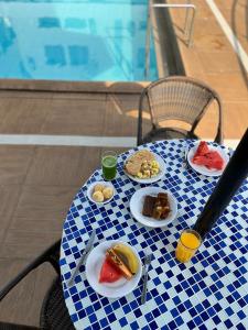 a blue and white table with plates of food on it at Hotel Fenice in Foz do Iguaçu