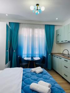 a bedroom with a blue bed with blue curtains and a table at maria house _2 in Kutaisi