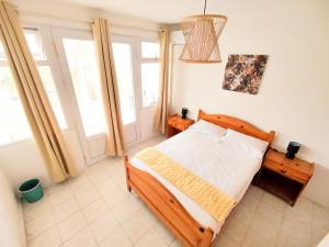 a bedroom with a bed in a room with windows at Fibonacci Beachfront Apartment in Flic-en-Flac