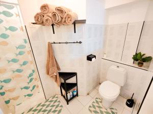 a small bathroom with a toilet and a shower at Fibonacci Beachfront Apartment in Flic-en-Flac