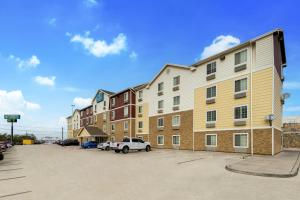 ein Apartmenthaus mit einem Auto auf einem Parkplatz in der Unterkunft WoodSpring Suites El Paso in El Paso