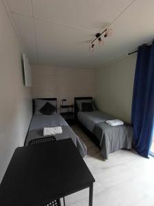 Zimmer mit 2 Betten und einem Tisch in der Unterkunft Domki303 in Mszczonów