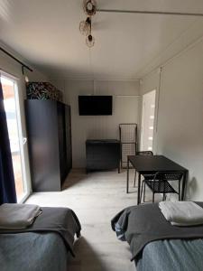 Zimmer mit 2 Betten, einem Tisch und einem TV in der Unterkunft Domki303 in Mszczonów