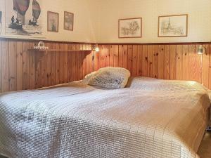 - une chambre avec un lit blanc et des murs en bois dans l'établissement Holiday home FIGEHOLM, à Figeholm