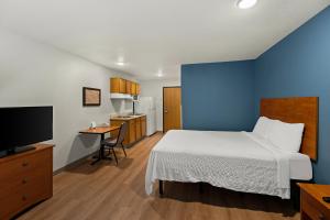 a hotel room with a bed and a television at WoodSpring Suites El Paso in El Paso