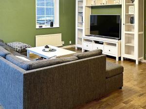 ein Wohnzimmer mit einem Sofa und einem TV in der Unterkunft Holiday home HÖÖR II in Höör
