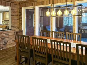 a dining room with a wooden table and chairs at Holiday home HÖÖR II in Höör