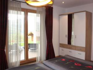 a bedroom with a bed and a large sliding glass door at Alpchalet Staufner Quelle in Oberstaufen