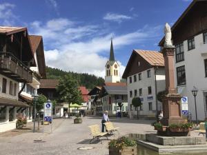 a person sitting on a bench in the middle of a town at Alpchalet Staufner Quelle in Oberstaufen
