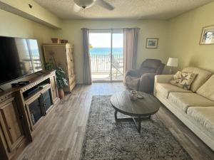 a living room with a couch and a tv and a table at Four Winds 402 by ALBVR - Amazing beachfront condo with private balcony & unbelievable views! in Orange Beach