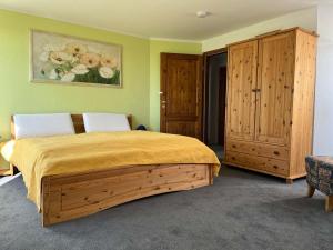 een slaapkamer met een groot bed en houten kasten bij Ferienwohnung Weitblick auf der Sonneninsel Fehmarn in Schlagsdorf