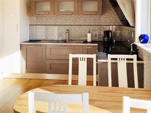 a kitchen with two white chairs and a table at 4 star holiday home in FAGERFJÄLL-By Traum in Åkervik