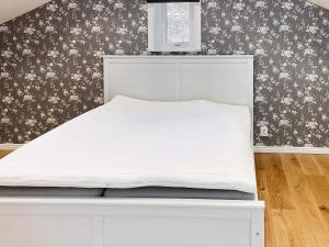 a bed in a bedroom with floral wallpaper at 4 star holiday home in FAGERFJÄLL-By Traum in Åkervik