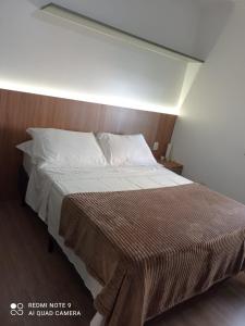 um quarto com uma cama grande e uma cabeceira em madeira em Ap 1 quarto Mobiliado em Gravataí
