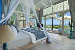 乌鲁瓦图Hidden Hills Villas - Small Luxury Hotels of The World的一间卧室，配有一张白色的床，可欣赏海景