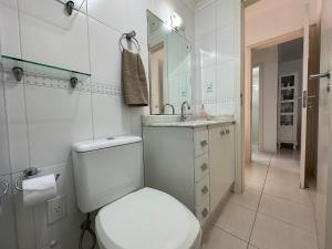 een witte badkamer met een toilet en een wastafel bij BC01- Suíte+1 | Centro | Churrasqueira | Garagem in Balneário Camboriú