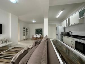 een woonkamer met een bank in het midden van een keuken bij BC01- Suíte+1 | Centro | Churrasqueira | Garagem in Balneário Camboriú